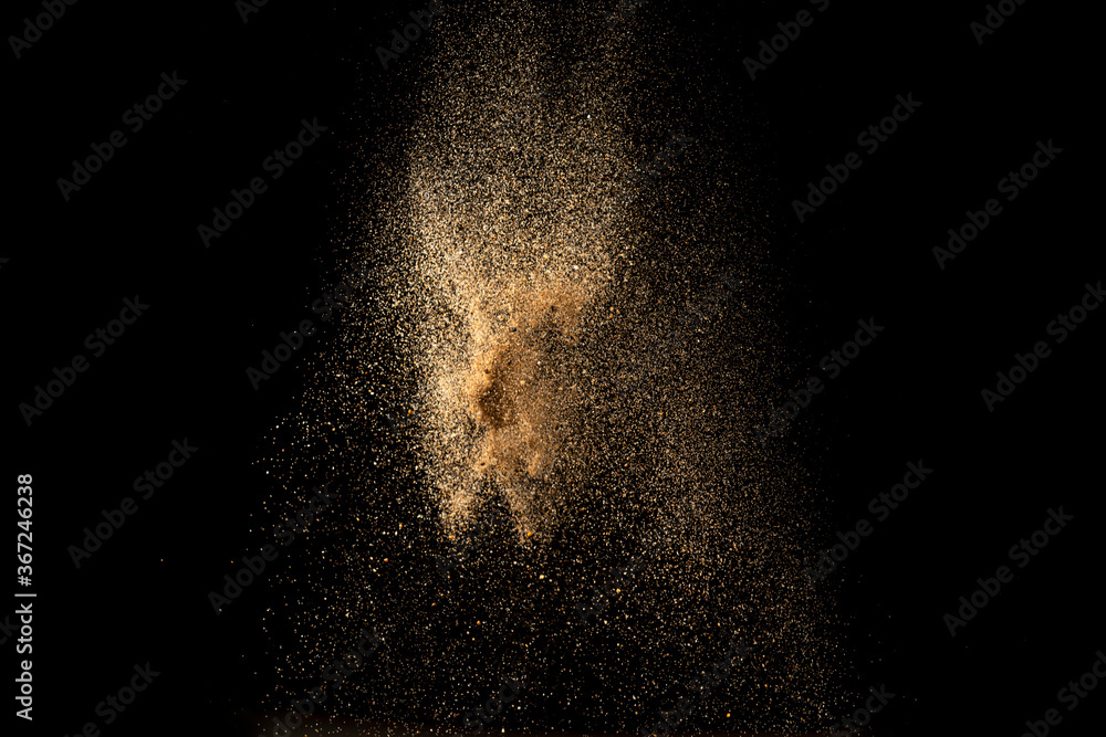 Wall mural gold sand explosion isolated on black background. abstract sand cloud.