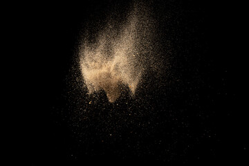Fototapeta na wymiar Gold sand explosion isolated on black background. Abstract sand cloud.