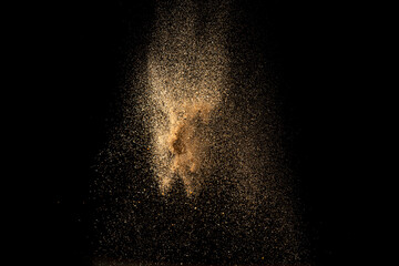 Gold sand explosion isolated on black background. Abstract sand cloud.