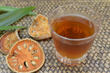 Bael juice Thai Herb with bamboo plate background.