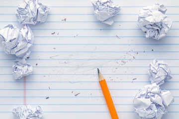 School supplies of blank lined notebook paper with eraser marks and erased pencil writing, surrounded by balled up paper and a sharp pencil. Studying or writing mistakes concept. - obrazy, fototapety, plakaty