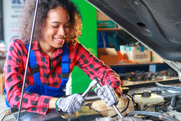 Female Mechanic working under the hood at the repair garage