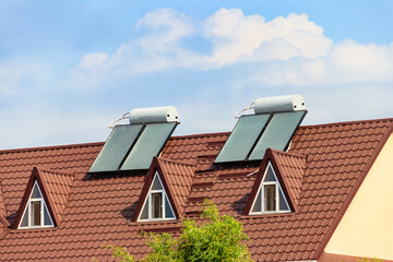 Solar water heaters on a residential house rooftop. Renewable energy for house