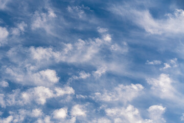 White clouds all over the sky with a blue background of daylight sky. Natural composition of the sky. Design element, background.