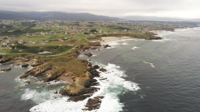 Beautiful Coastline view and waves crashing on rocky cliff shoreline. Aerial Drone Video
