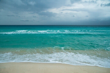 Paradise. Seascape. Turquoise color  water sea. The white sand and ocean waves under an enchanting cloudy sky in Cancun, Mexico. 