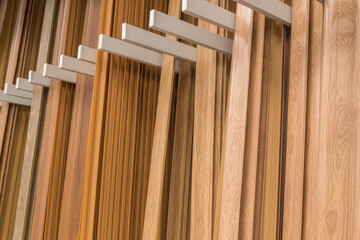 Floor skirting boards of various brown and beige shades for wood, standing vertically in rows,...