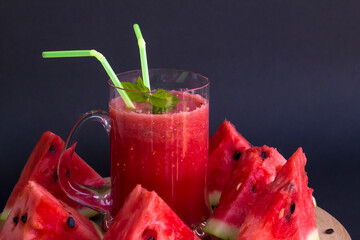 Natural juice of watermelon in glass on wooden tray with sliced watermelon,dark background