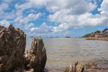 Rocks and boats at sea and blue skies