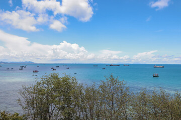 Colorful of tree and rocks in the sea and blue sky