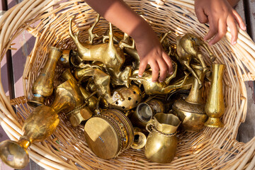 Child playing with a variety of brass collectible objects
