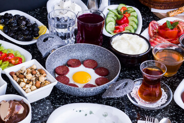 Egg with sausage in egg pan on granite marble table with a fork,top view and flat layout.