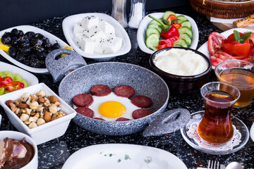 Traditional Turkish Breakfast with sausage egg pan on granite marble table.Close and large view         