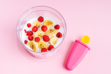 Step by step instruction. Homemade raspberry ice cream. Step 3. Put raspberries and banana in a blender, pour yogurt. Home cooking concept. Hobby and activities at home.