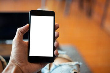mock up man hand using smartphone In the coffee shop,Screen blank with clipping path