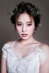 Asian young woman styling headdress with flowers