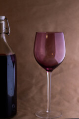Wine bottle with glass on brown background