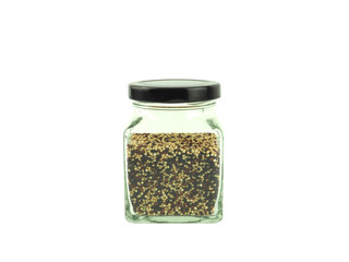 Organic tri-color Quinoa in a glass bottle with black lid isolated on a white background. High fiber, Superfood..