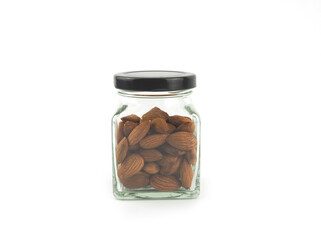 Organic almonds seed in glass bottle with black lid isolated on a white background. Healthy food..