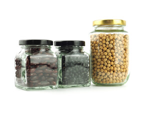 Dried different legumes in a glass bottle with a lid (Soybeans, Red kidney beans, black gram) isolated on a white background. Healthy nutrition food concept..