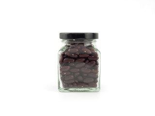 Red kidney beans in a glass bottle with black lid isolated on a white background. High protein,...