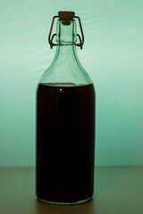 Wine bottle with glass on light green background