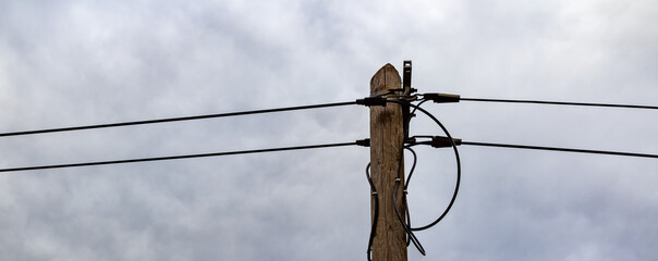 wooden telephone mast and wire, cloudy sky