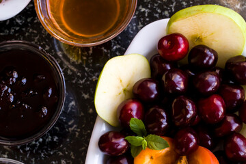 Detail shot of the breakfast table with fresh cherry,jam and honey.
