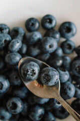 Fresh ripe blueberry on spoon. Dark background of sweet black berries