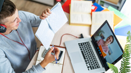 student shows their homework via a video conference chat with a teacher