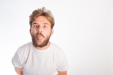 Obraz premium portrait of a young guy with rusty hair and tanned skin who is fooling around on camera. space for text. isolate on a white background