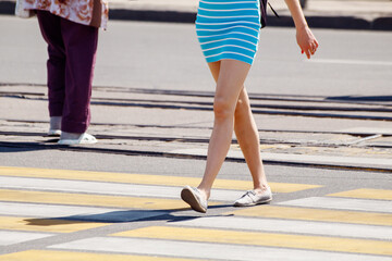 young woman crossing the road at a pedestrian crossing