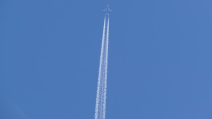a trail of burned plane fuel high in the sky