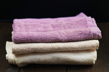 Towels over dark wooden background. Spa products