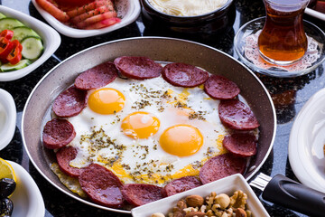 Traditional Turkish Breakfast with sausage egg pan on granite marble table.Close and large view          