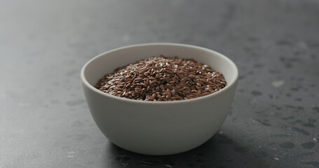 flaxseed in white bowl on terrazzo countertop with copy space