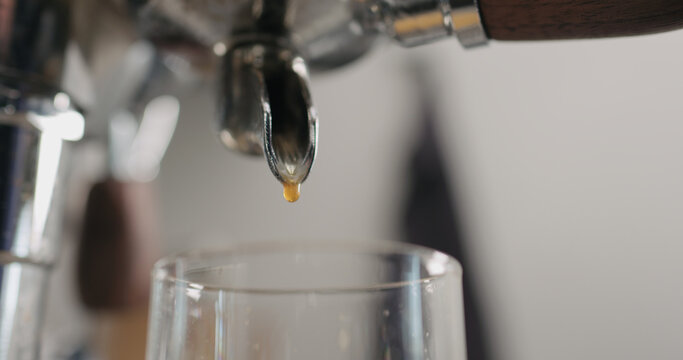 Low angle shot of espresso pour from coffee machine ingo glass cup