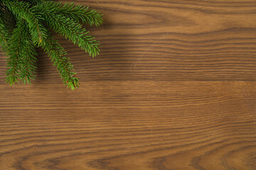 Flat lay christmas background with spruce twigs on ash wood surface