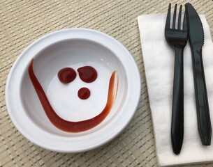 Creepy ketchup smile on a paper plate
