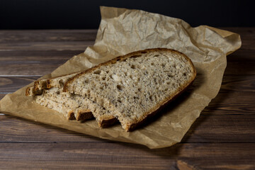Freshly baked slice of bread sliced ​​on wrapping paper.