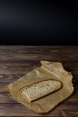 Freshly baked slice of bread sliced ​​on wrapping paper.