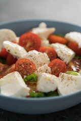 salad with mozzarella, tomatoes and lettuce in blue bowl