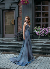 Cheerful happy joyful woman laughing merrily on backdrop gray building, brick wall, blooming...