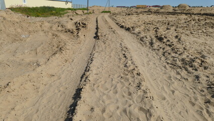 track on the sand from the wheels of heavy-duty transport