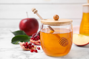 Honey, apples and pomegranate on white marble table. Rosh Hashanah holiday