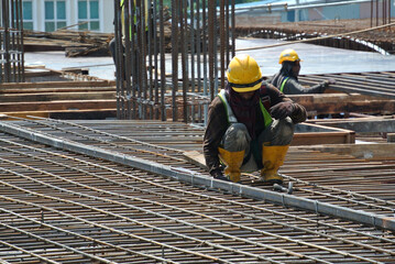 MALACCA, MALAYSIA -MAY 16, 2016: Construction workers fabricating steel reinforcement bar at the...