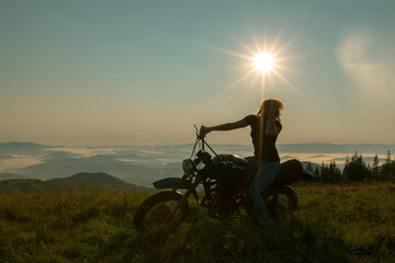 girl on a motorcycle travels in the mountains