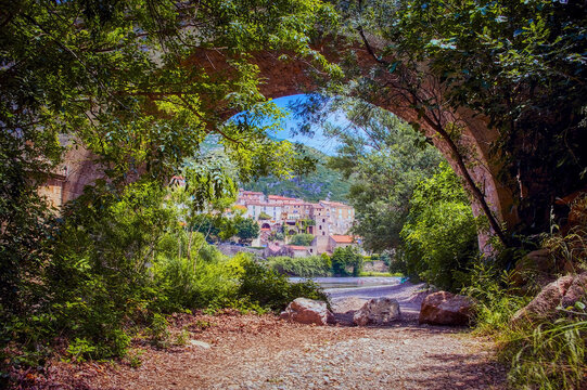 Under an arch of the old stone bridge at Roquebrun, in the Saint Chinian wine district of the Herault, Languedoc Roussillon, France