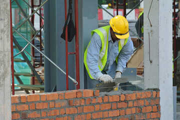 JOHOR, MALAYSIA -APRIL 05, 2016: Bricklayer install clay bricks for building walls.
