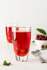 Summer delicious cherry compote with pulp in glasses on a white background